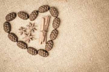 Fototapeta na wymiar Chocolate candies with liquor in form of heart on background of burlap bag texture. Vintage old style for chocolate day, selective focus and copy space for any design or text