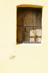 Fensterluke / markantes und mit Holz verbarrikadiertes Fenstergitter 
