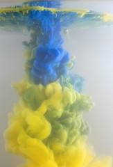 Blurred blue and yellow ink in water