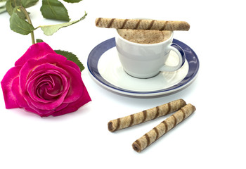 cup of coffee on a saucer and a bright rose