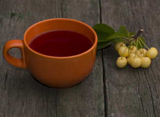 big orange mug of juice and berry of white sweet cherry