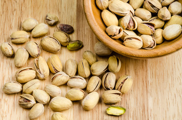 roasted and salted pistachios on wooden background