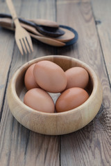 The eggs in the wooden bowl with spoon and fork