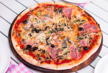 Italian delicious hot pizza on wooden plate, on white table