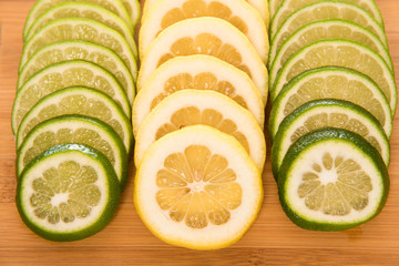 Lemon and lime slices on a wood cutting board
