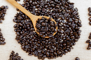 Closeup coffee beans on wooden spoon vertical style