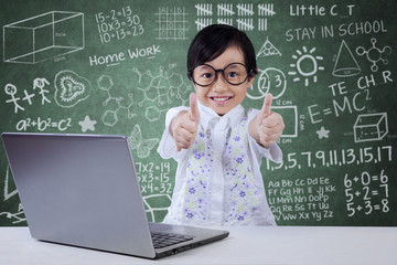 Kid with laptop shows OK sign