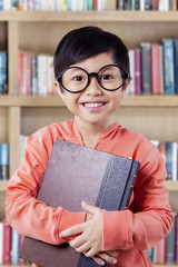 Joyful little girl with book smiling on the camera