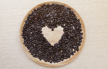 Heart shape coffee beans on wooden plate