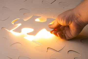 Missing jigsaw puzzle piece with light glow, business concept for completing the final puzzle piece