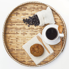 Coffee raisin muffin and hot coffee on wood tray