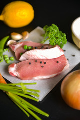 Raw pork and vegetables on black table,selective focus