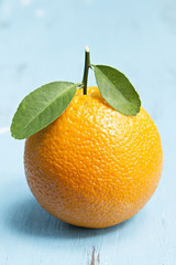  Orange with leaves on wooden background.