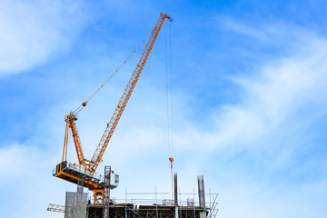 Fototapeta na wymiar Building crane and construction site under blue sky