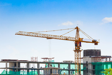 Building crane and construction site under blue sky