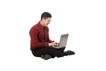 Asian business man working on a laptop and sitting on the floor