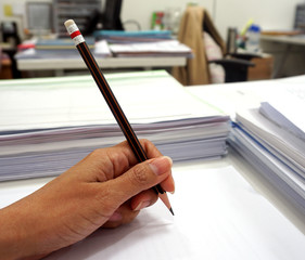  Women's hand grip a pencil writing on the white paper