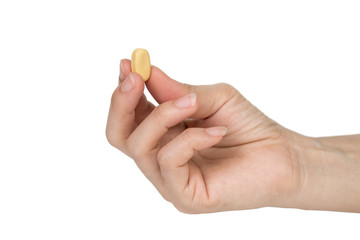 Woman's hand holding pills on a white background.