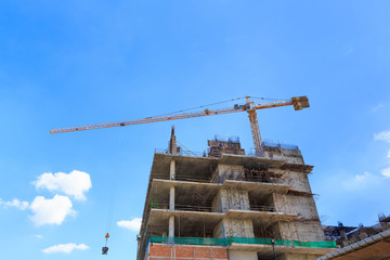 Building crane and construction site under blue sky