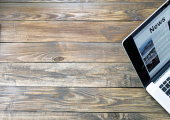 Digital subscription on rough wooden desk concept.
Handcrafted natural wooden texture table with large copy space and cropped laptop with world news page on screen