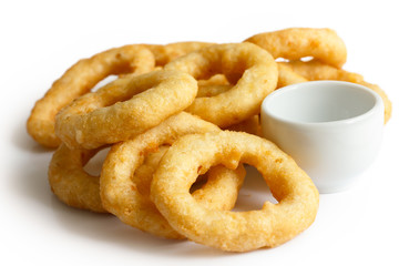 Heap of deep fried onion or calamari rings with dipping dish iso