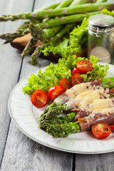 Baked green asparagus with prosciutto and cheese