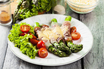 Baked green asparagus with prosciutto and cheese