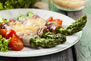 Baked green asparagus with prosciutto and cheese