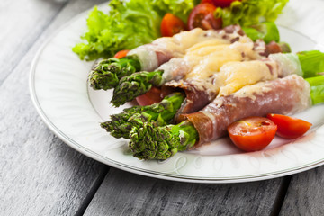 Baked green asparagus with prosciutto and cheese