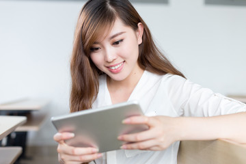 Fototapeta premium Asian beautiful female student study with tablet in classroom