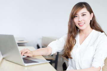 Asian  beautiful female student study with laptop in classroom