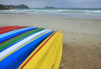 Stock Photo - Row of Kayaks beside the sea