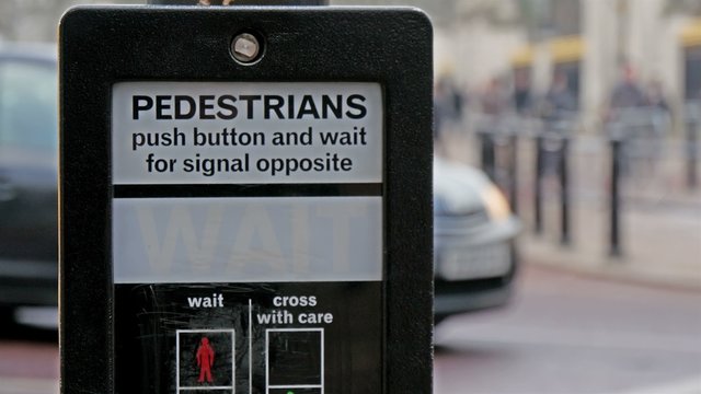 Its a go signal for pedestrian in London street. The signage signals its okay to cross the street then says wait mean dont cross yet