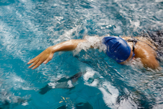 Female swimmer in an indoor swimming pool - doing crawl