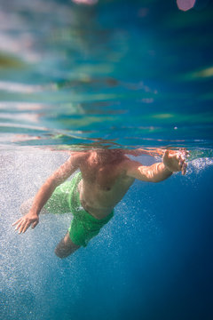 Young male snorkeler diving in the sea