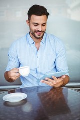 Smiling businessman using a tablet