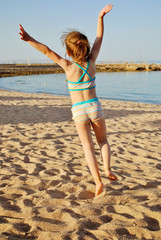 Little girl jumping on the beach - 86029038