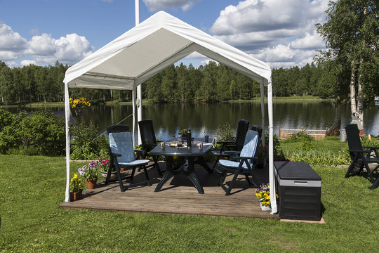 A tent in a yard in front of a river