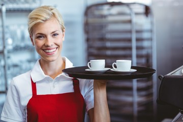 Pretty barista holding two cups of coffee