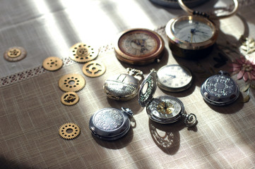Different watches and cogwheels, gearwheels in steampunk style on a table