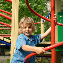 Obraz premium Cute young boy playing on playground.