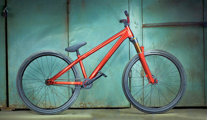 Red bicycle on a green garage background