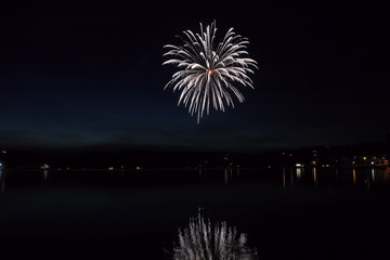 Colorful fireworks with reflection on lake.