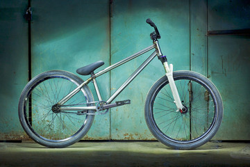 Fototapeta na wymiar Silver bicycle on a green garage background