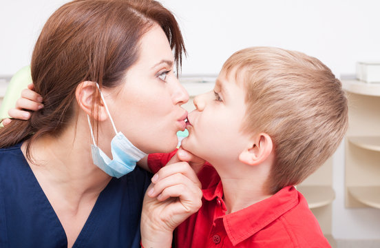 Daring and bold kid kissing dentist woman