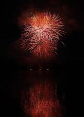 Colorful fireworks with reflection on lake.
