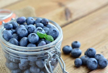 Blaubeeren - Heidelbeeren in Glasgefäss auf Holztisch