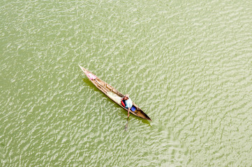 Malagasy rafter man rowing traditional canoe on river, Madagasca