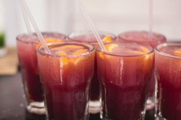 Beautiful line of different colored alcohol mojito cocktails with mint on a open air party, tequila, martini, vodka, and others on decorated catering bouquet table on open air event party.
