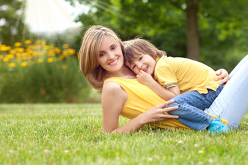 Fototapeta na wymiar Young beautiful mom and her cute little boy, relaxing and having